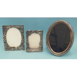 Two modern silver-plated photograph frames with embossed scenes, 13 x 10cm and 11 x 8cm and one