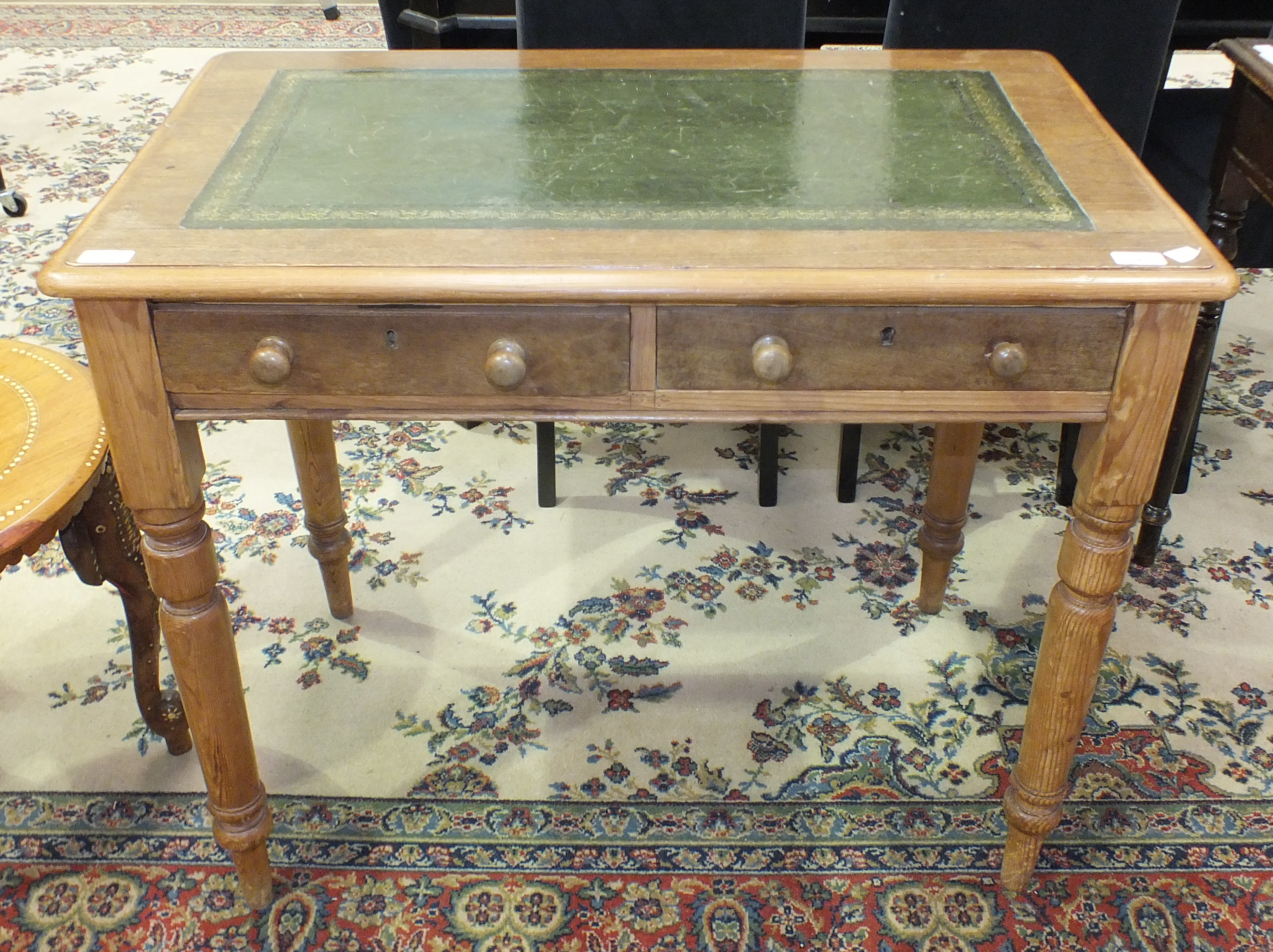 A stained pine two-drawer writing table, the rectangular top with inset writing surface, on turned