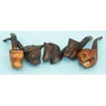 A collection of five carved wooden smoking pipes, the bowls carved as a cow, a horse, a human skull,