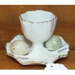 A Carltonware egg cup, 6cm high, with a salt and pepper in the form of two bird's eggs.