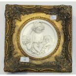 A pair of circular plaster wall plaques decorated in relief with putti, 16cm diameter, within gilt
