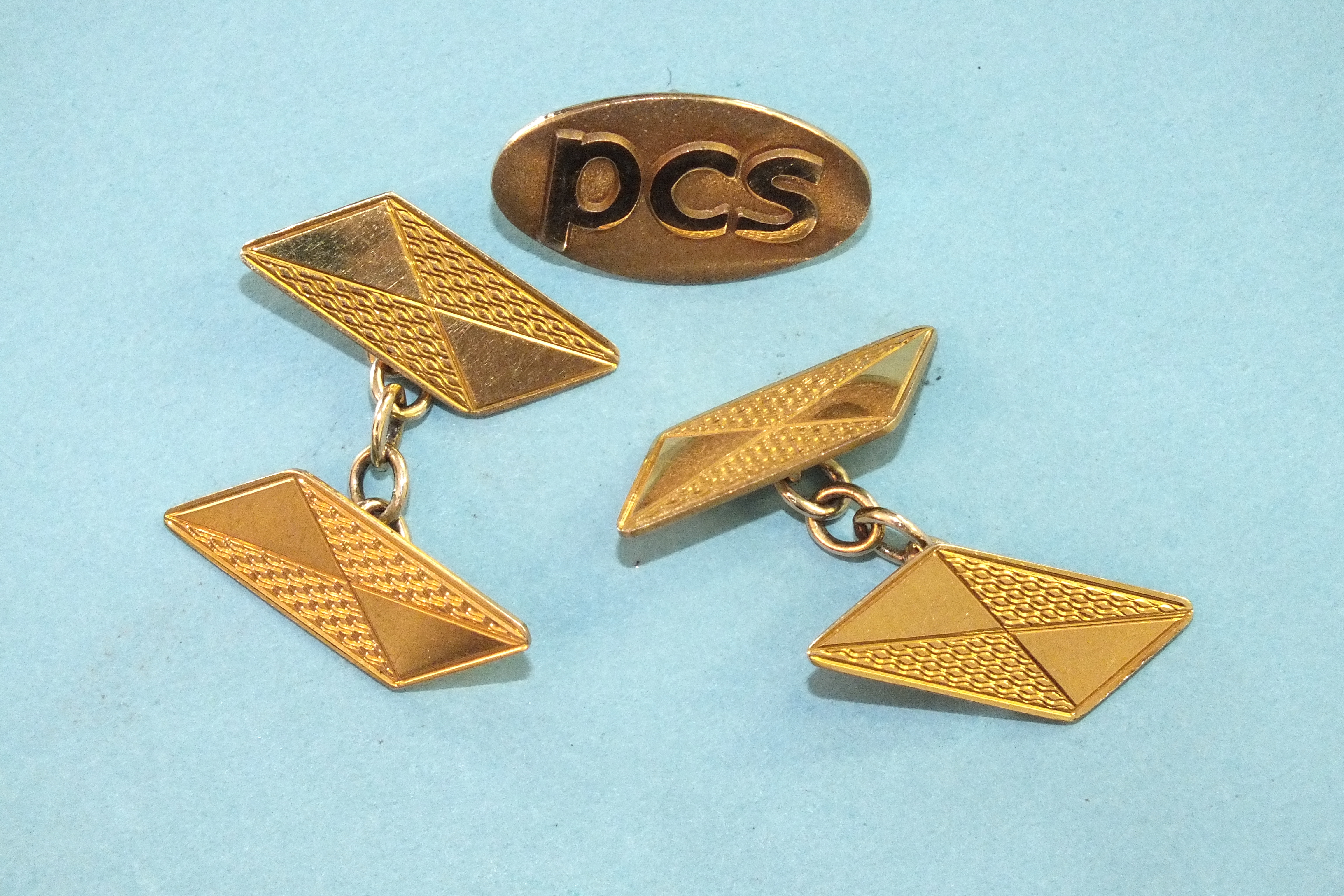 A pair of engine-turned 9ct gold cufflinks of parallelogram form, 3.9g and a 9ct gold tie tack.