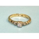 A diamond ring set a brilliant-cut diamond between two diamond points, in 18ct gold mount, size