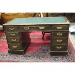 An Edwardian oak pedestal writing desk with inset writing surface and three frieze drawers, above