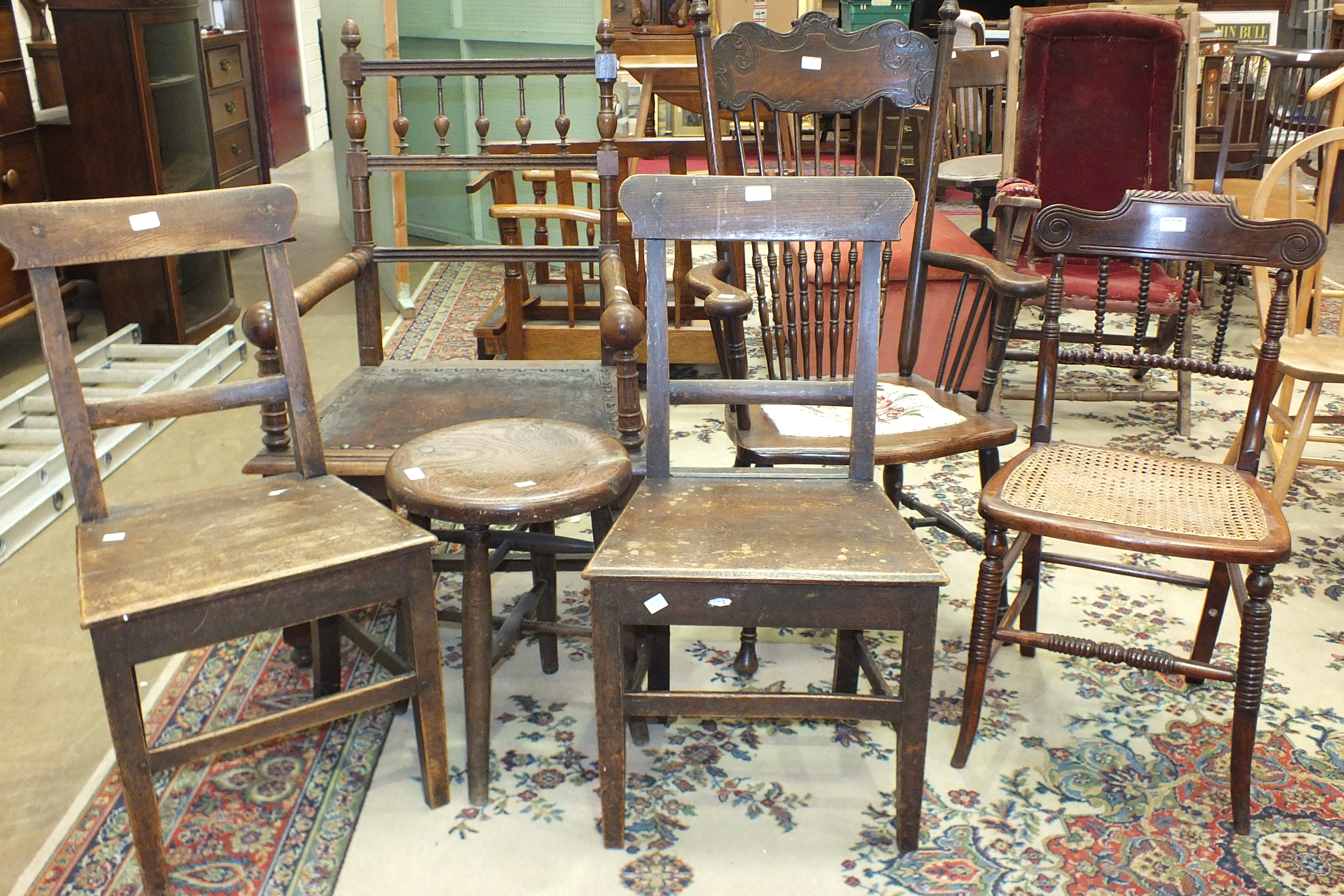 An oak turned wood armchair of generous proportions, with worn leather-covered seat, two oak