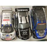 Three radio-controlled battery-powered cars with plastic bodies.