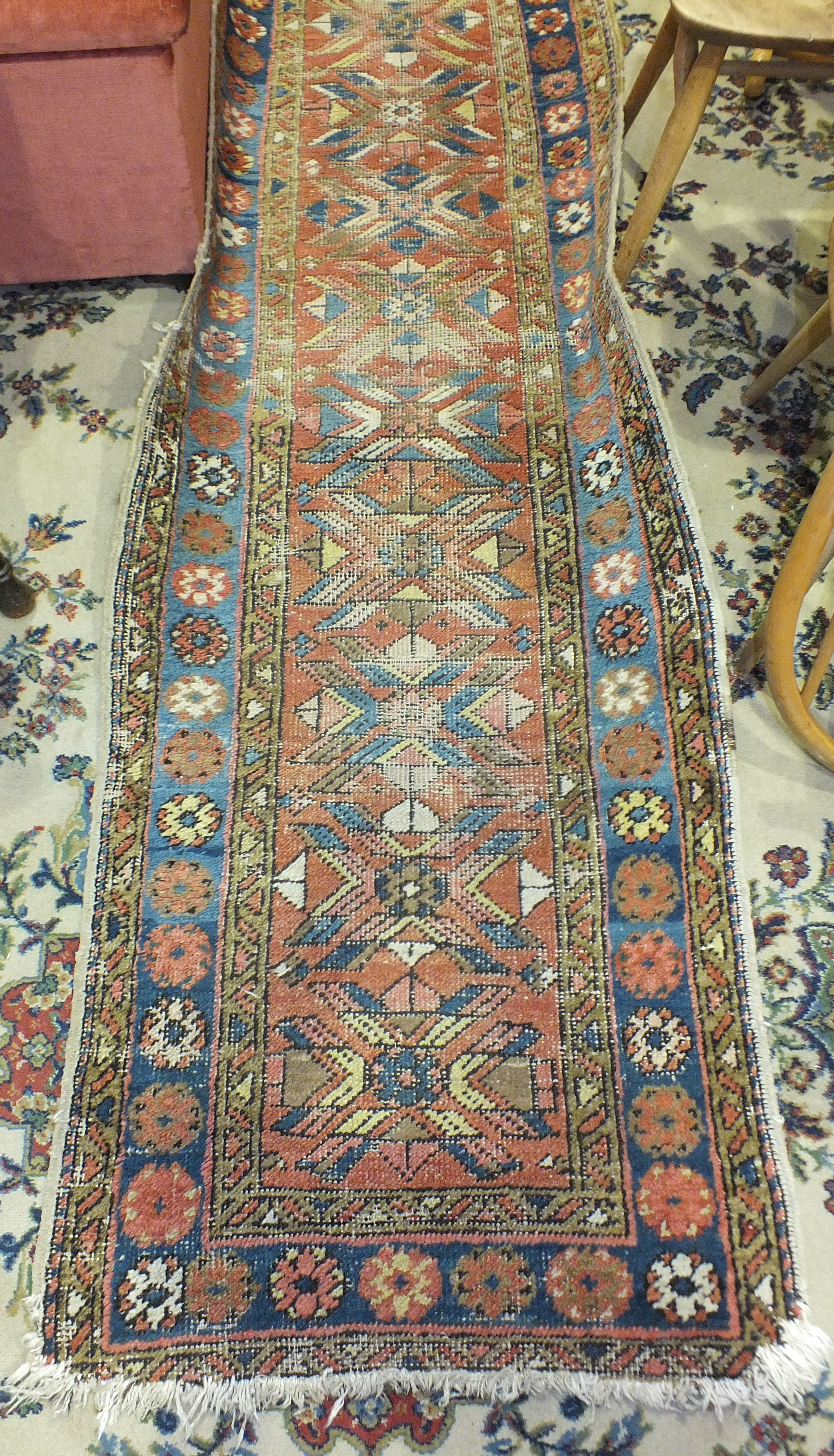 An Eastern runner with geometric and floral decoration, 252 x 70cm, (a/f, worn).