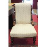 A Victorian mahogany upholstered low salon chair on turned legs.
