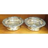 A pair of silver-plated bottle coasters with turned wood bases, 18cm diameter, (2).