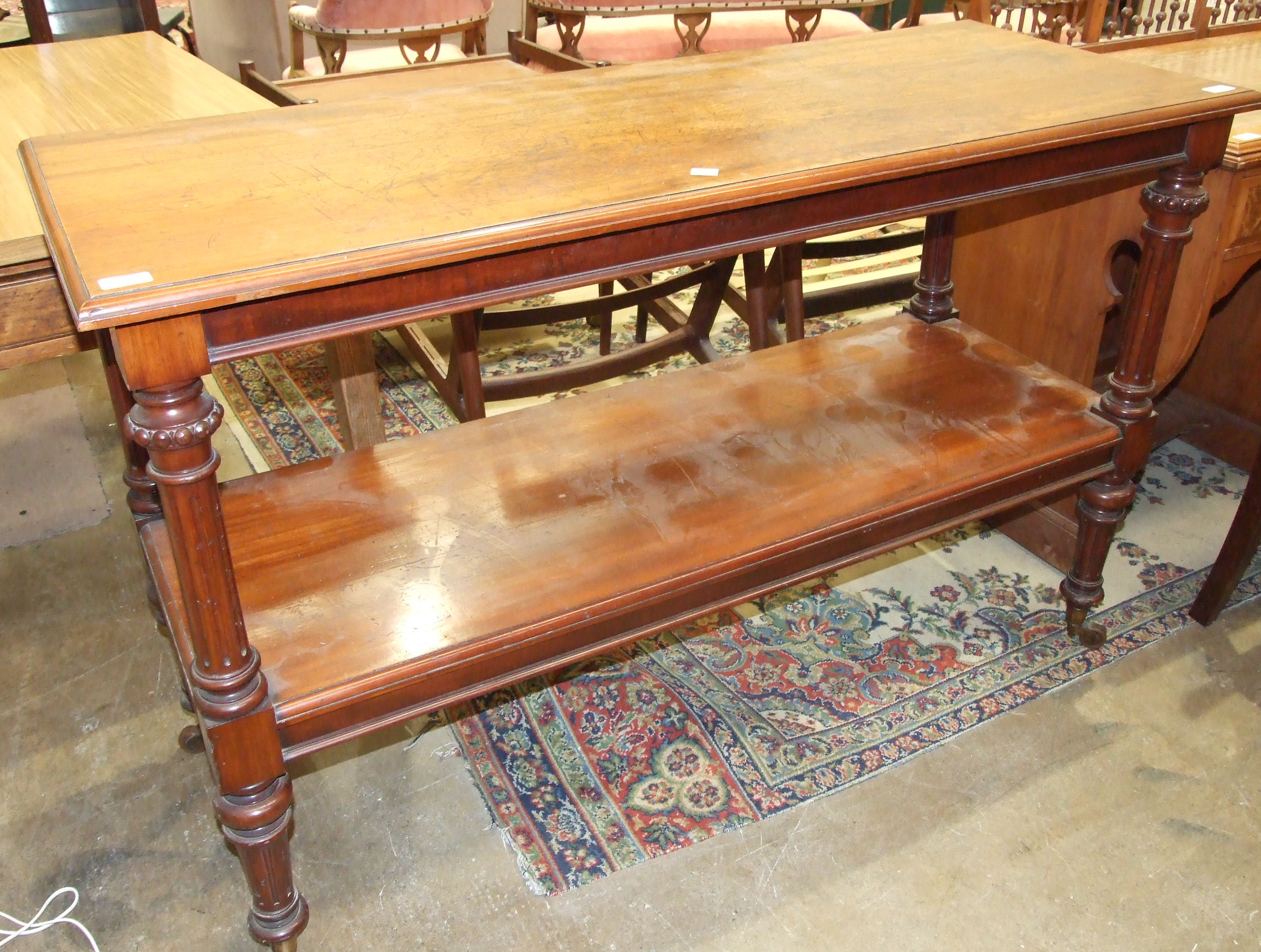 A late-Victorian mahogany rectangular two-tier whatnot on reeded supports and legs, 136cm wide, 88cm