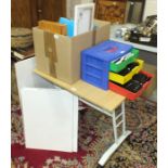 A collection of artist's materials, crayons, paints, canvasses and an artist's drawing table.