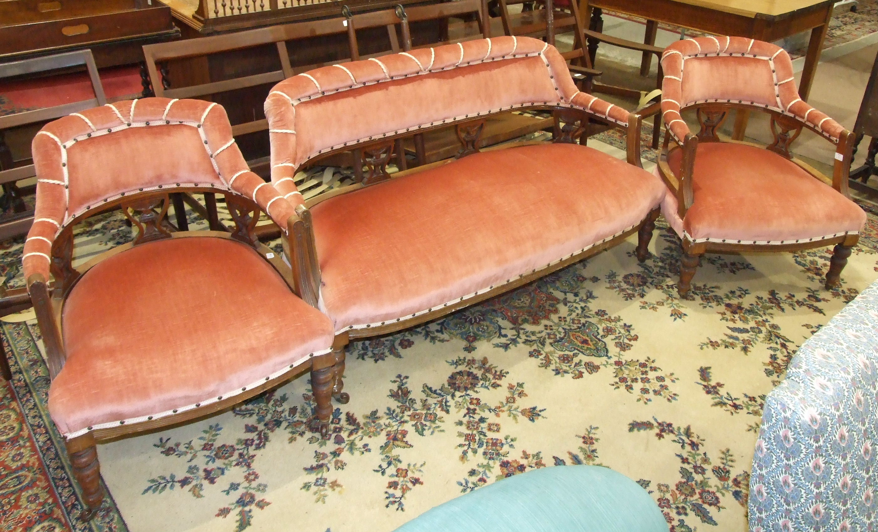 An Edwardian walnut-framed lounge suite, comprising a two-seater settee with upholstered back,