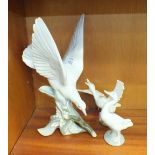 Three Lladro figures of a turtle dove on a branch, 28cm, a goose with wings outstretched, 13cm and a