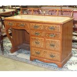 A late-19th/early-20th century walnut kneehole desk, the rectangular top with leather inset, above