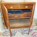 A 1960's walnut two-door office cupboard, the pair of panel doors enclosing two drawers and ten