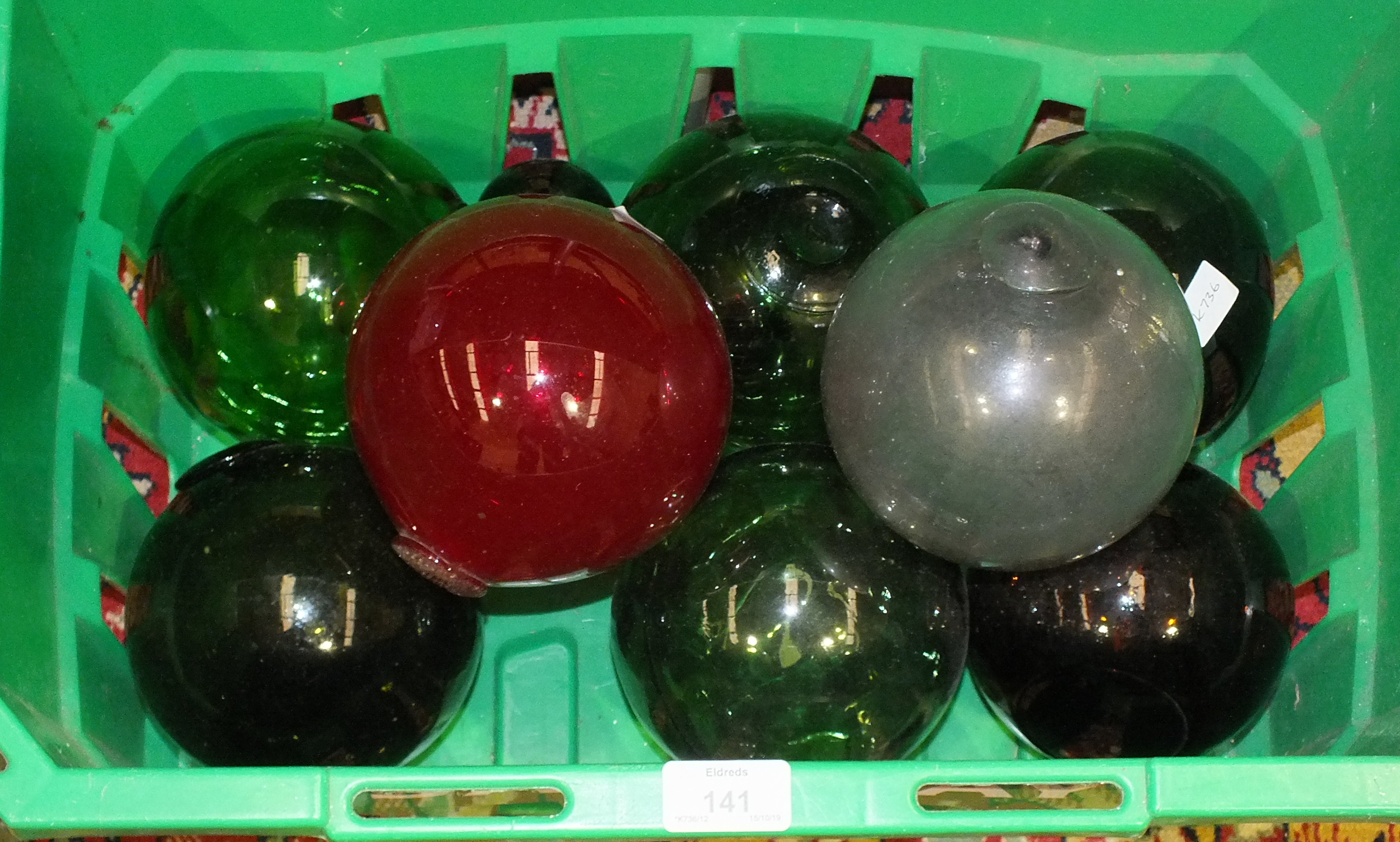 A collection of nine coloured glass fishing floats, (9).