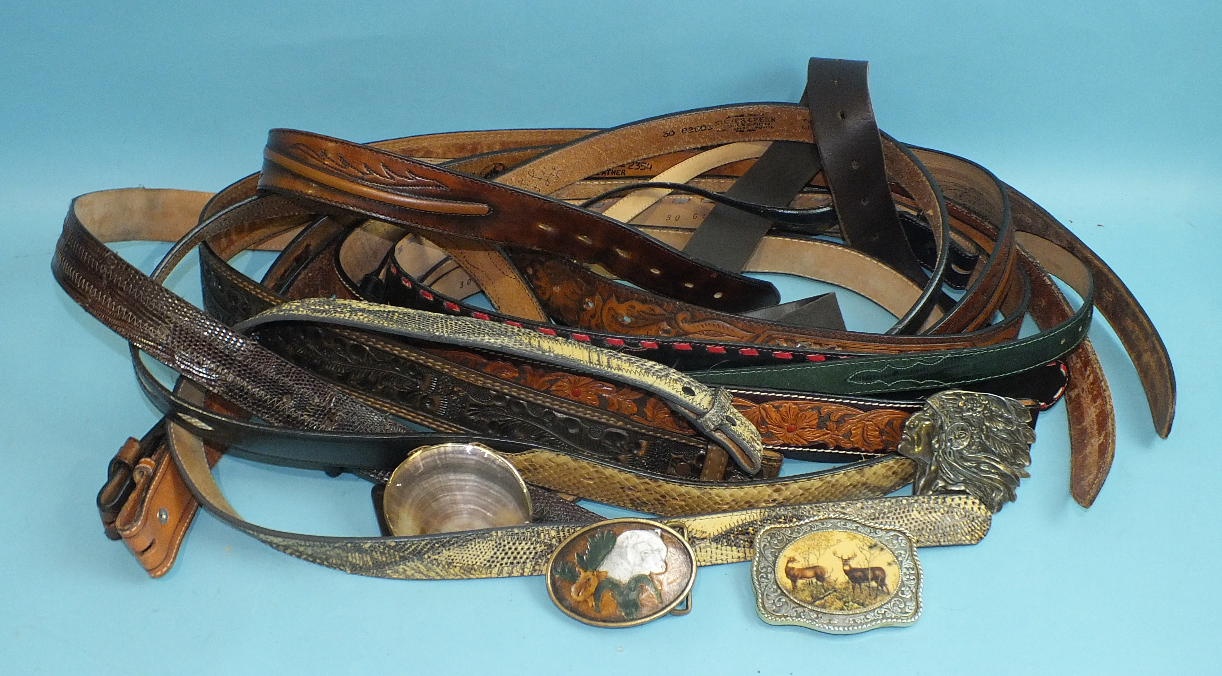 A collection of eleven Tony Lama and other tooled-leather belts and four decorative belt buckles, (