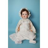 A Heubach Köppelsdorf bisque head baby doll with sleeping blue eyes and cropped mohair wig, on