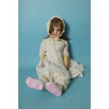 An Armand Marseille bisque head doll with sleeping blue eyes and brown replacement wig, on jointed