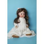 An Otto Reinecke bisque head baby doll with sleeping brown eyes, replacement wig, on dressed