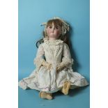 A Petite Francaise J Verlingue Liane bisque head doll with fixed blue glass eyes and brown wig, on