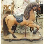 A carved wood push-along horse on cast iron wheels, 77cm high, 81cm long, (no handle).