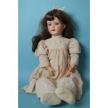 An Armand Marseille bisque head doll with sleeping blue eyes and replacement wig, on jointed