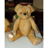 A large 1950's teddy bear, possibly J K Farnell, with orange and black glass eyes, vertically-