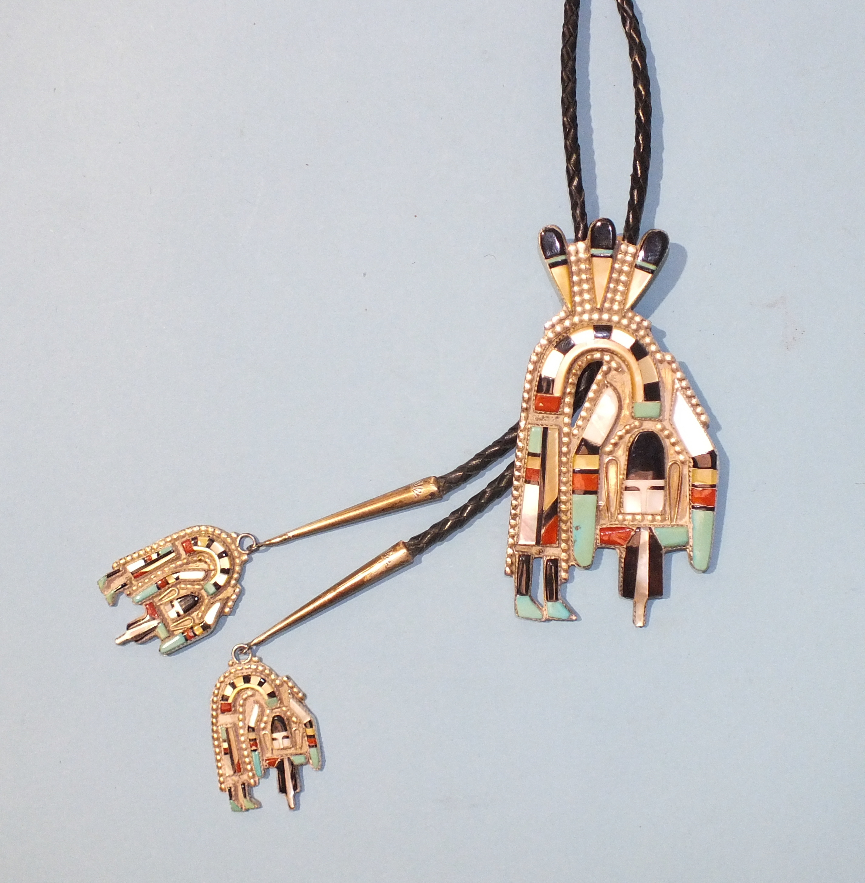A Henry Cellicion Zuni white metal Rainbow Man bolo, set with mother-of-pearl, turquoise and stones,