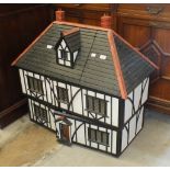 A large scratch-built half-timbered doll's house, the front opening to reveal four rooms, hall