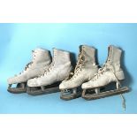 Two pairs of lady's white leather ice skates.