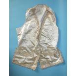 A late-18th/early-19th century ivory satin waistcoat with applied braid to the edges and faux