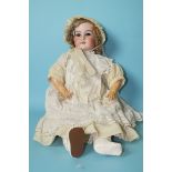 An Armand Marseille bisque head doll with sleeping blue eyes and blonde mohair wig, on jointed