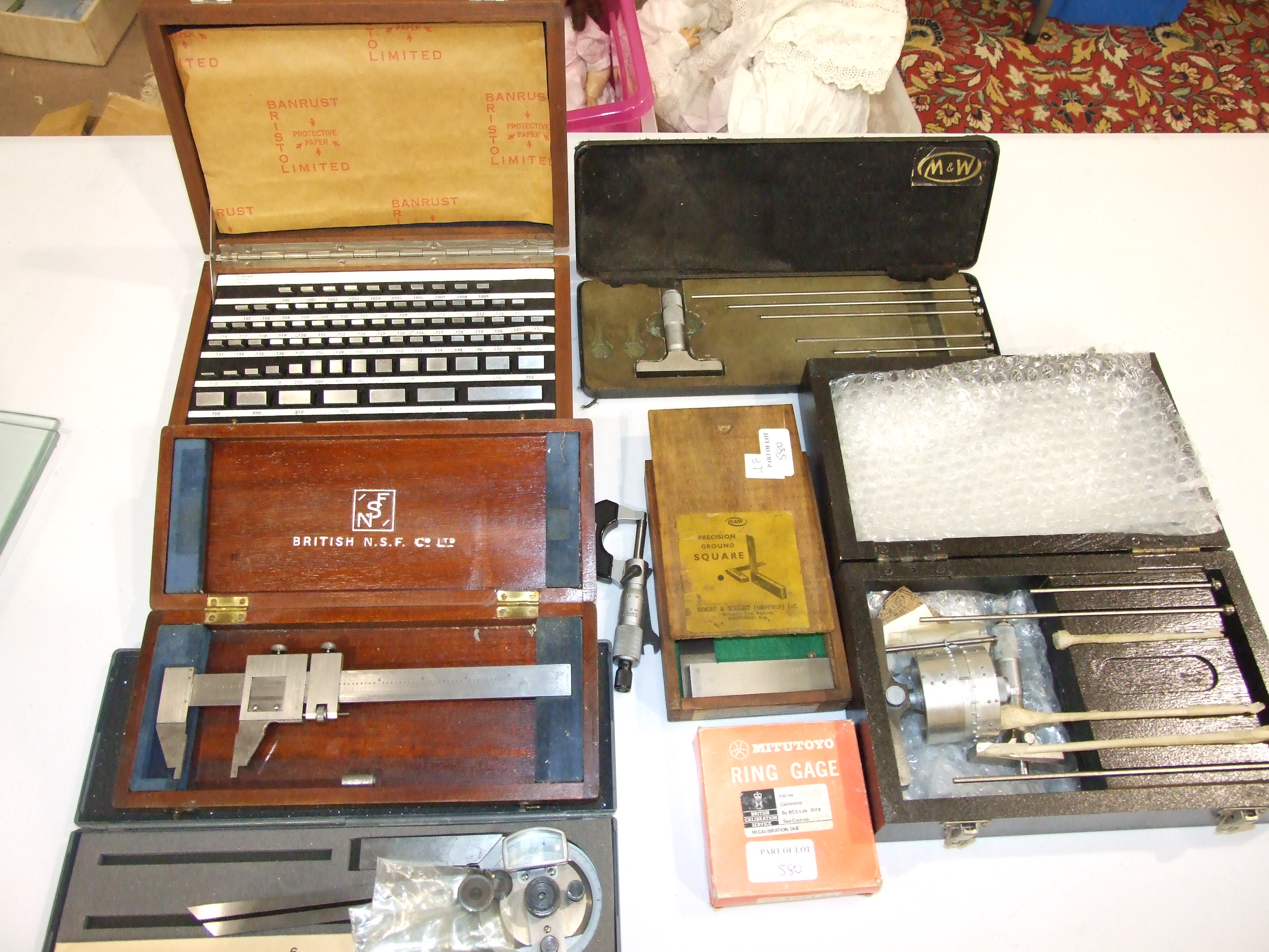 A collection of engineering tools, including Moore & Wright micrometers, precision ground square,