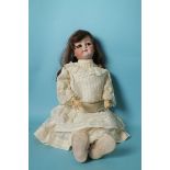 A German bisque head doll with sleeping brown eyes and brown wig, on jointed composition body, in