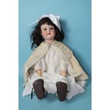 An Armand Marseille bisque head doll with sleeping blue eyes and dark brown wig, on jointed