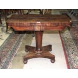 An early-19th century mahogany fold-over card table on tapered octagonal column and concave base,