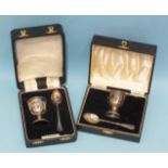 A cased silver christening set of an egg cup and spoon, Birmingham 1927/28 and a similar later boxed