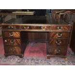 A modern mahogany kneehole office desk fitted with frieze and pedestal drawers, 137cm wide.