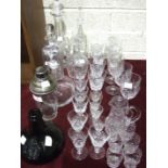 An etched glass cocktail shaker with plated mount, various cut-glass decanters and other glassware.