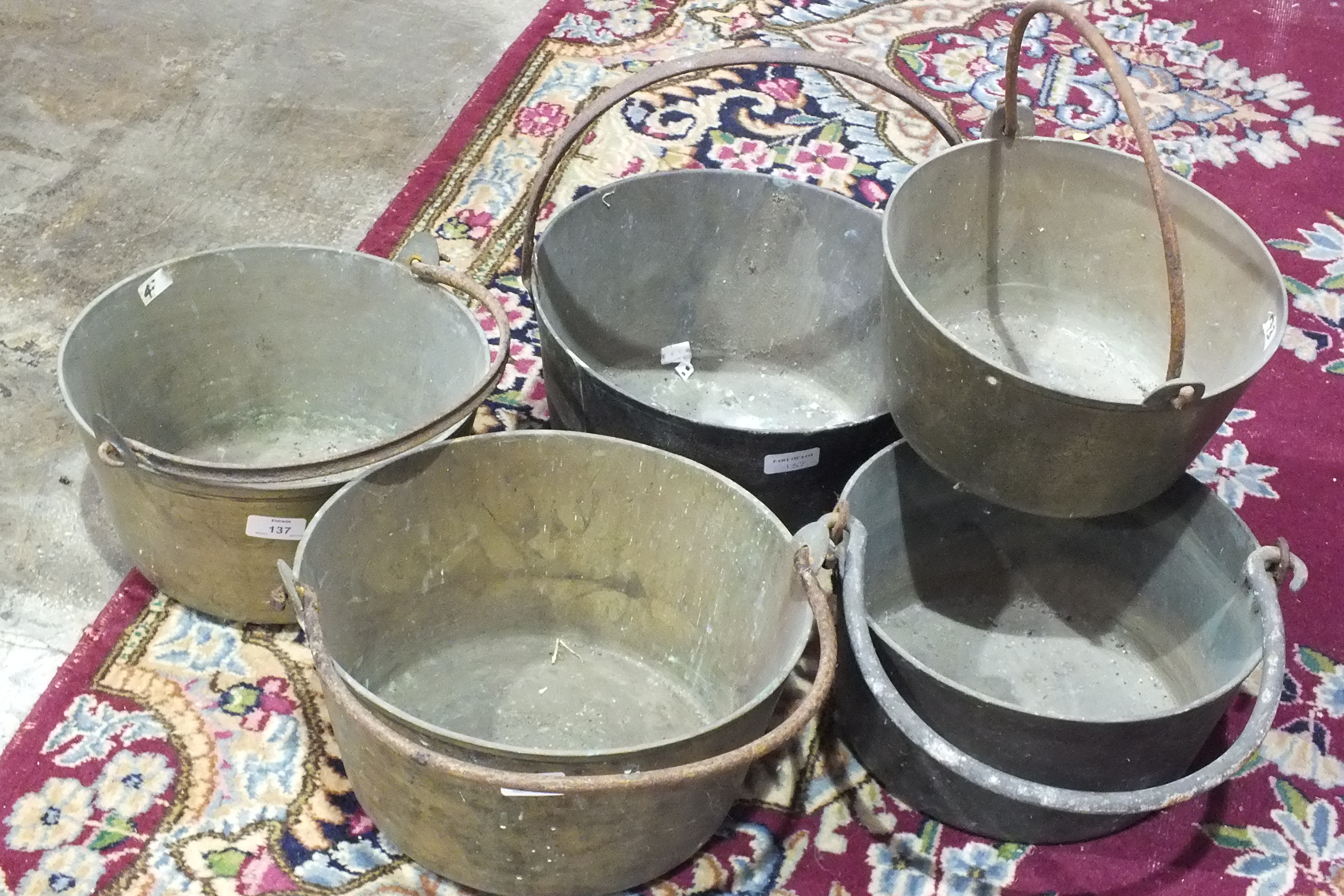 Five brass and metal-handled jam pans.