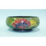 A Moorcroft Pottery bowl and cover decorated with hibiscus flowers on a green ground, marks to