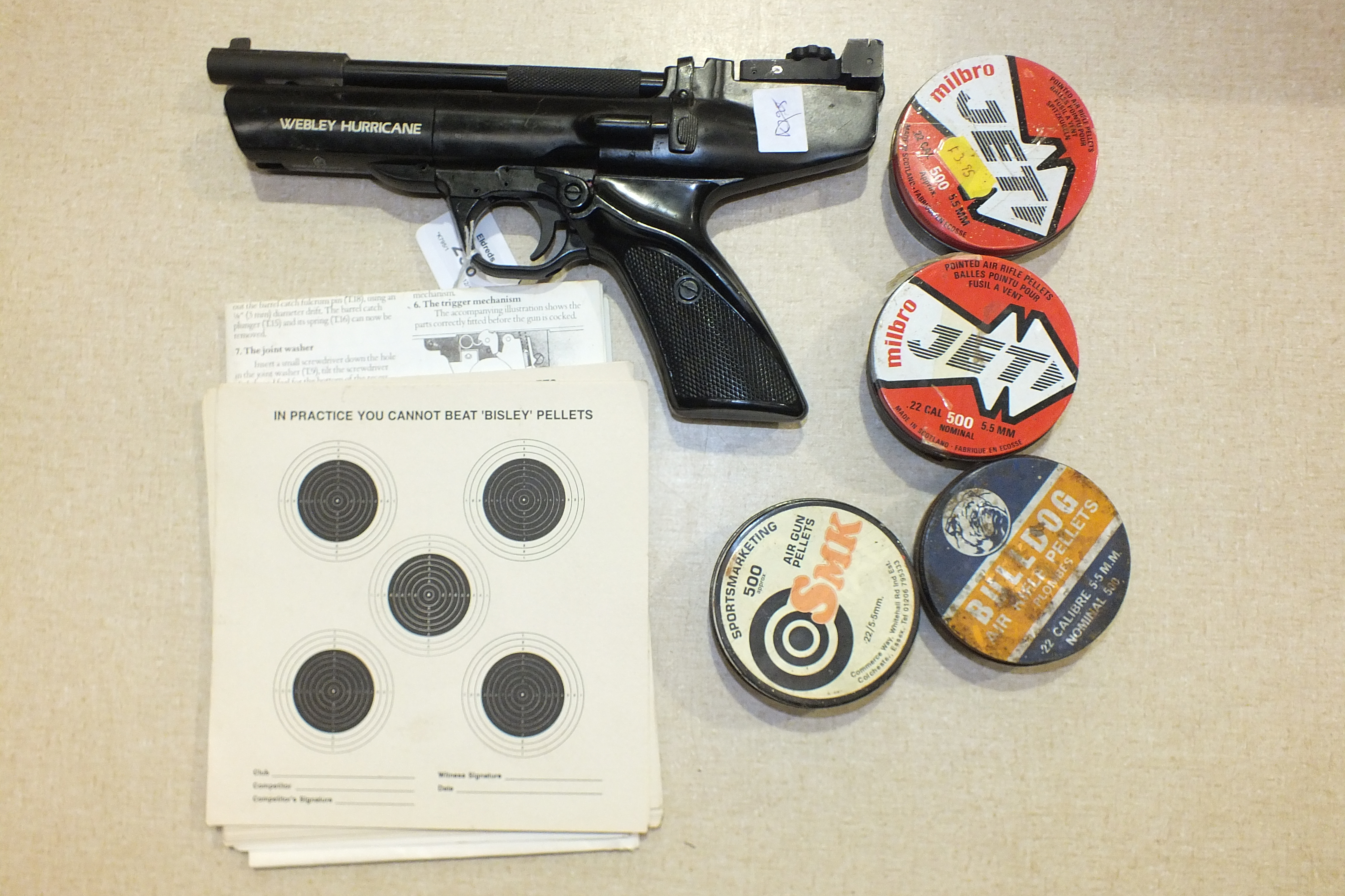 A Webley Hurricane .22 air pistol with pellets and targets.