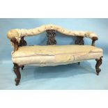 A Victorian walnut carved two-seater settee, the open back with upholstered top rail and
