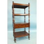 A Victorian mahogany four-tier whatnot, the second tier with frieze drawer, on brass castors,