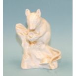 An unmarked, unpainted bone china prototype model of a field mouse holding a nut, 9cm high,