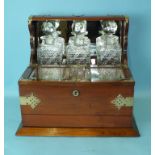 A metal-mounted mahogany Tantalus with three cut-glass decanters and cigar humidor, above a