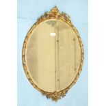 A pair of Victorian oval gilt-gesso wall mirrors, each bevelled plate within a frame moulded as