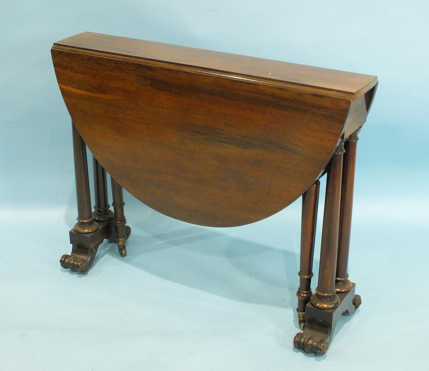 A Victorian rosewood drop-leaf Sutherland table with a pair of oval drop leaves, on turned legs