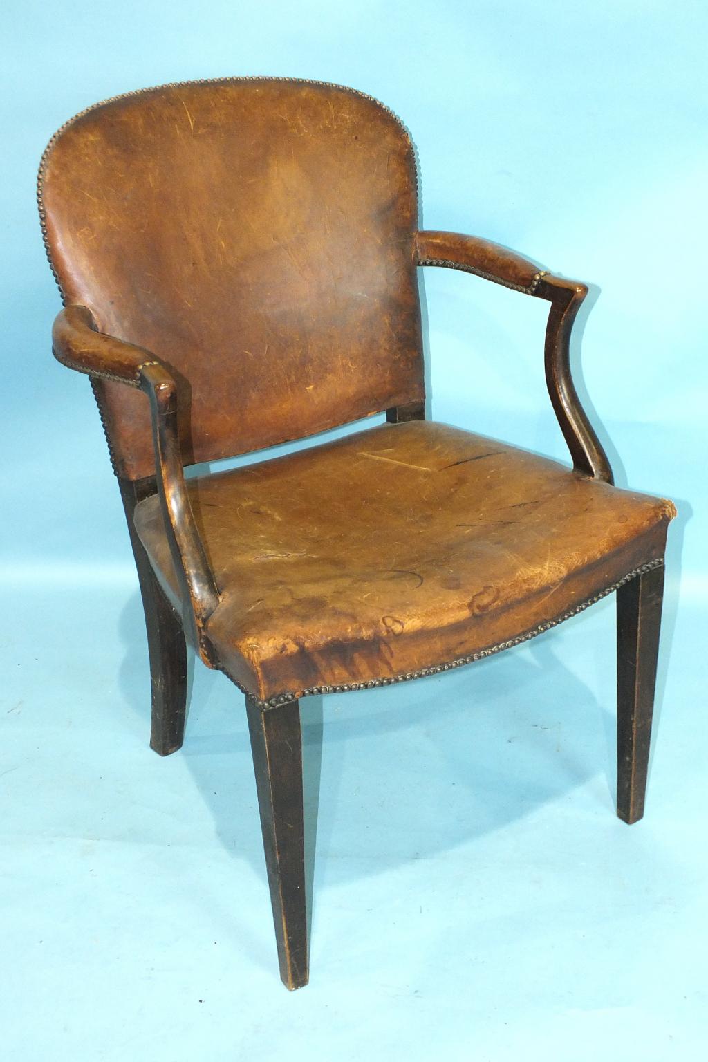 A 19th century mahogany leather-upholstered armchair, on square tapered legs.